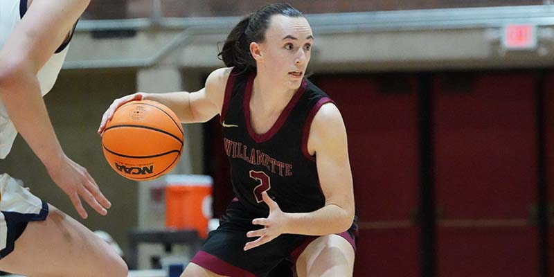 Sami Riggs controls the basketball for Willamette.