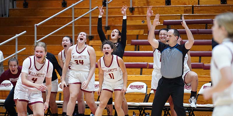 The Willamette Bearcats cheer as the referee signals that Emma Floyd (not pictured) has scored on a three-point basket.