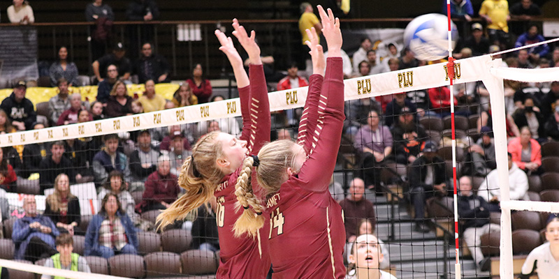 Kaitlyn Westby, left, and Syd Bowen, right, leap to block an attack by PLU at the NWC Tournament.