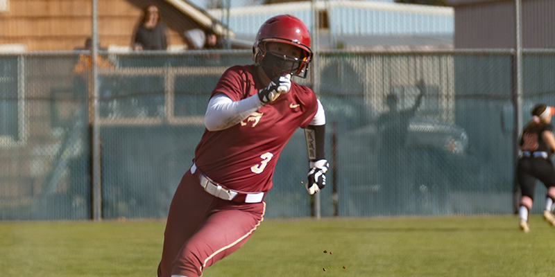 Close-up of Mia Lund rounding third base and preparing to run toward the plate.