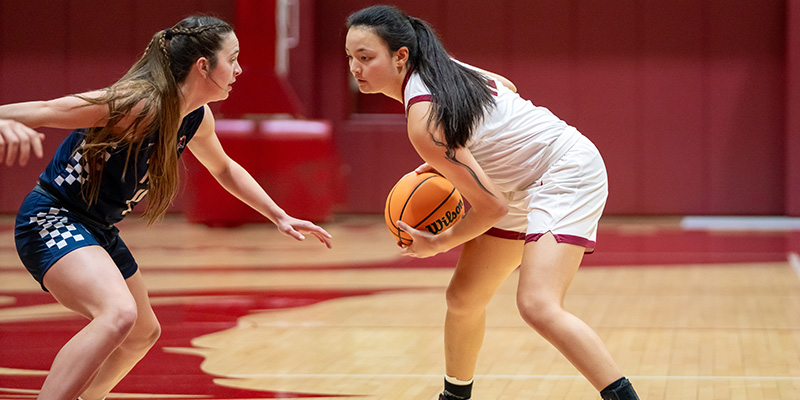 Carolyn Ho controls the ball while facing a defender.