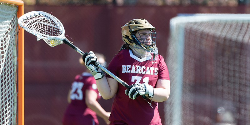 Goalkeeper Shelby Sawyer has the ball in her lacrosse stick.