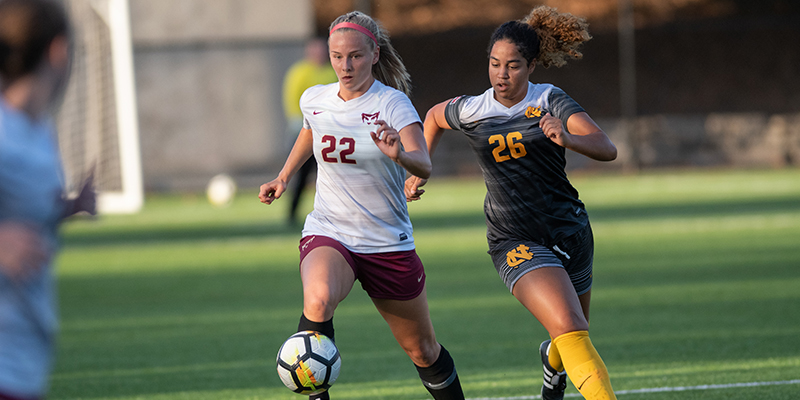 Clara Mattison retains possession of the ball as she moves beside a defender.