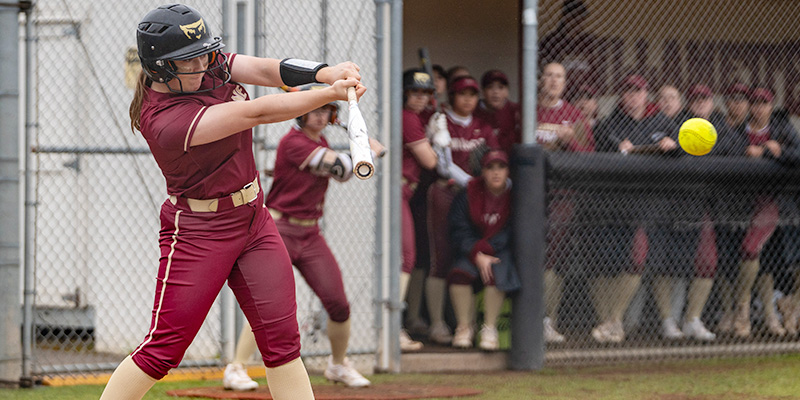 Mia Rogers starts to follow through on a swing after hitting the ball.
