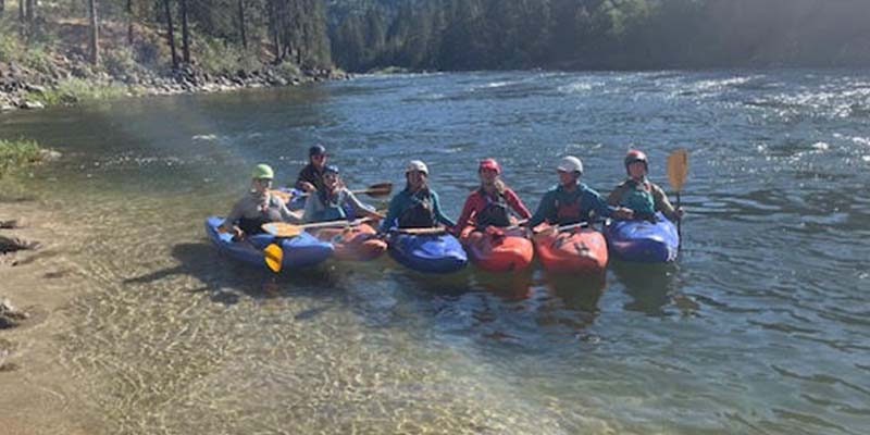Claire Bonnet, in front row, fourth from the right, and six other people are ready to begin a kayaking trip.