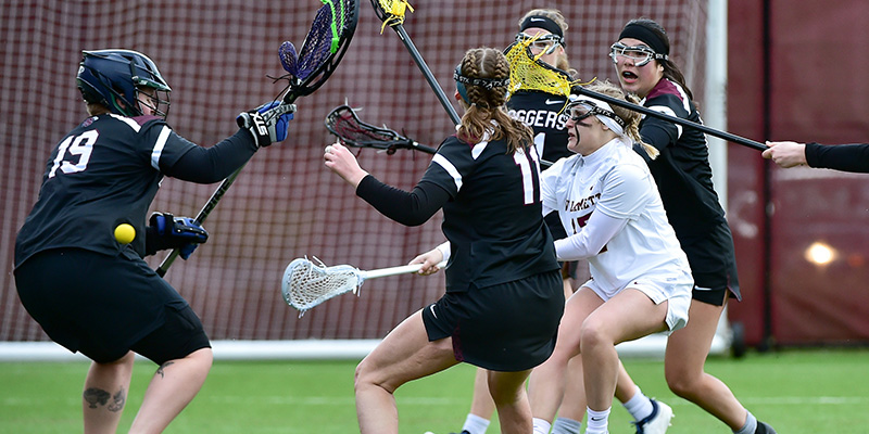 Claire Kisielnicki shoots past the goalie while surrounded by defenders.